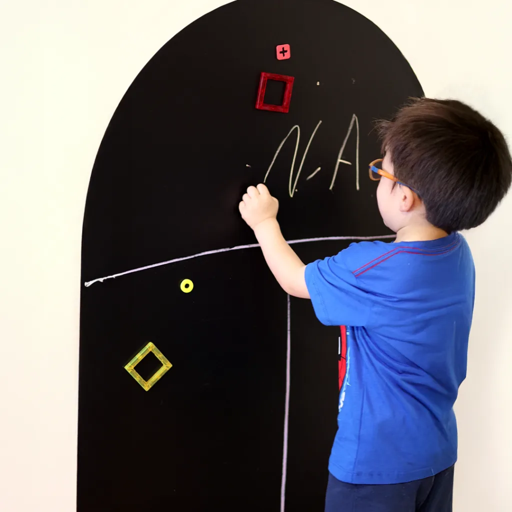 Niño jugando con su pizarra arco Negro